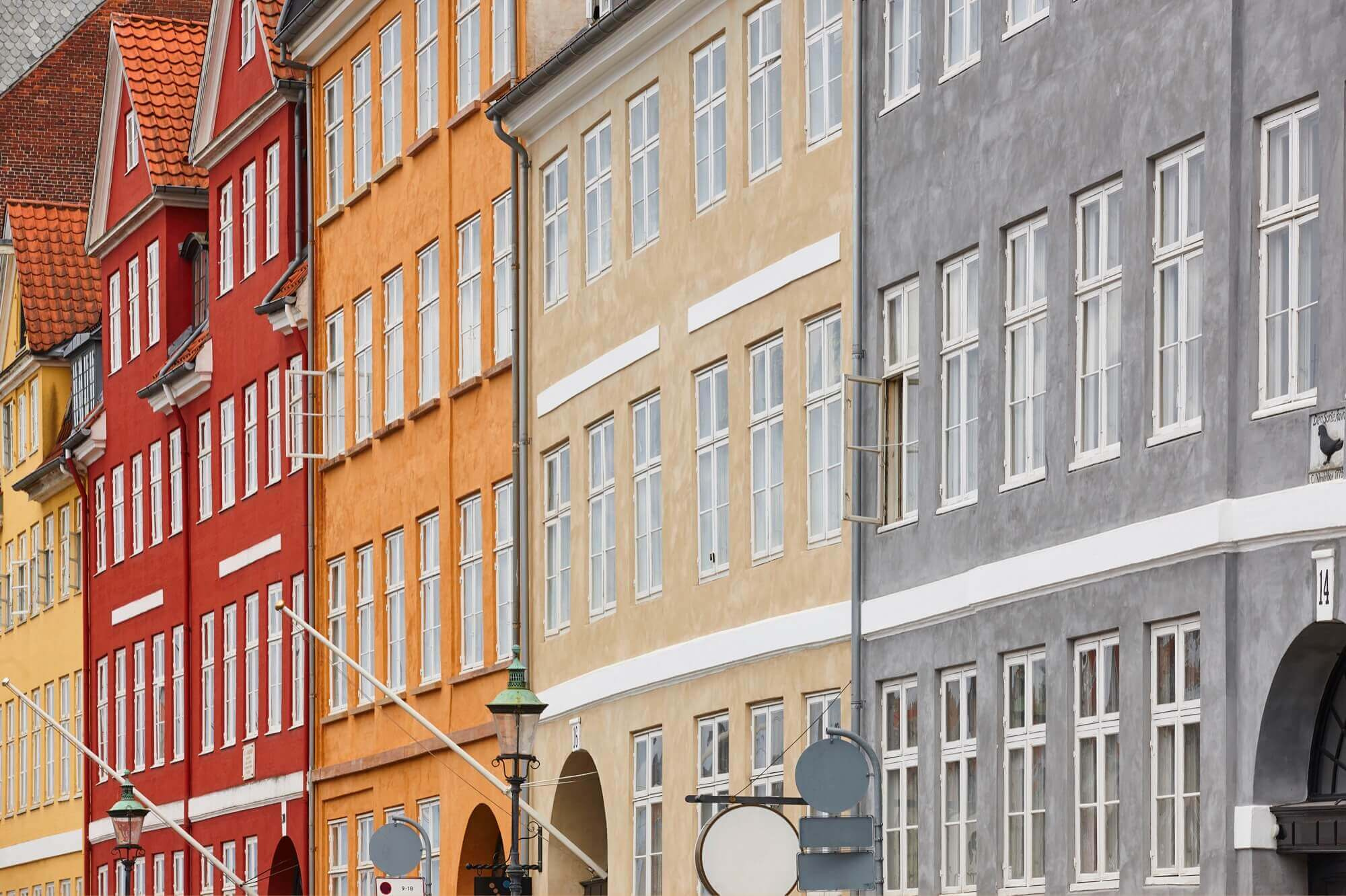 Rad av färgglada stadshus med nymålade fasader, ett tydligt exempel på fasadmålning i olika kulörer.